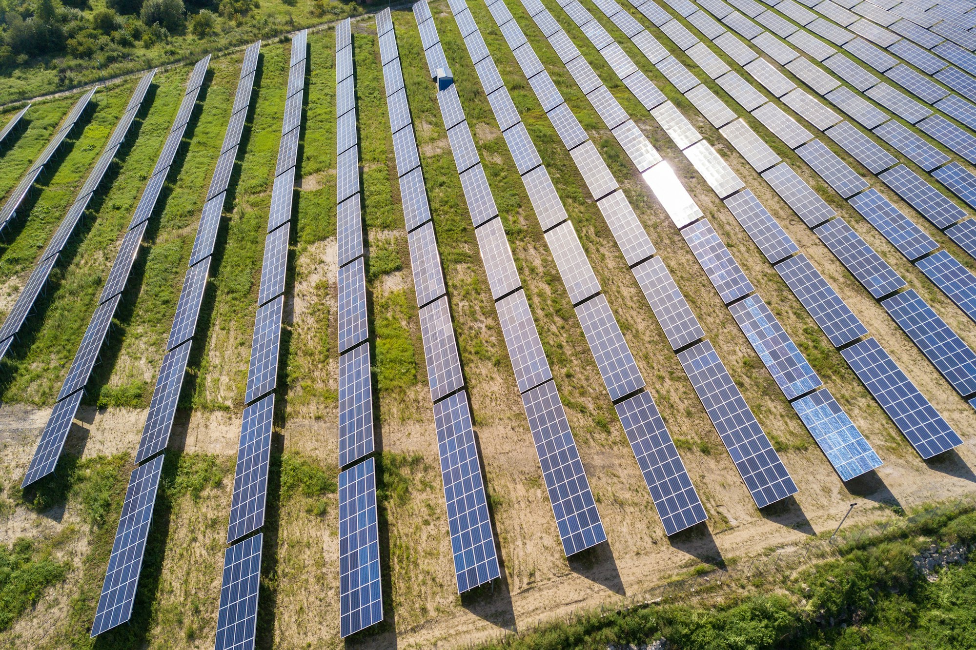 Aerial view of solar power plant on green field.