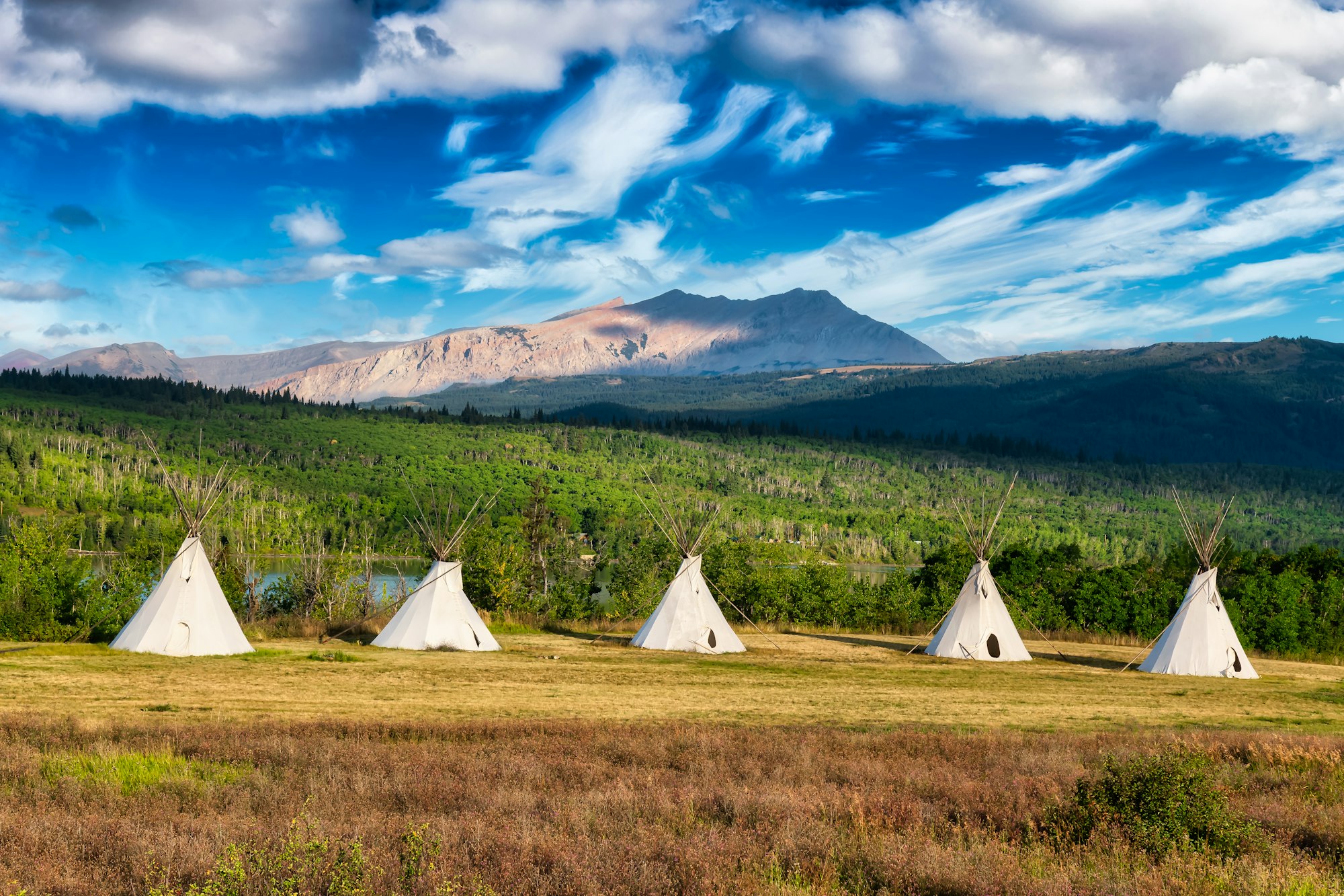 Tipi in a field with American Rocky Mountain Landscape in the background